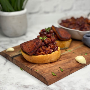 Texas BBQ Skillet: Hearty, savory, fragrant, southern flair casserole with a depth of rich spices. Fiber, protein and minerals loaded pinto beans baked with carrots in a rich smoky tomato sauce topped with tofu bacon, served with crispy garlic bread.